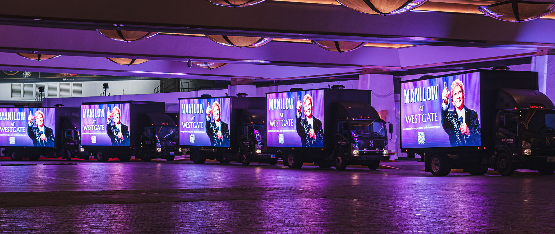 Group of five Digital Billboard Trucks parked in a line, advertising berry Manilow.